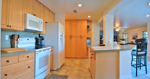 Kitchen alternate view showing range, microwave, and full cabinetry layout