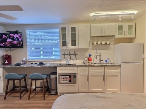 Open-plan kitchen and dining area with modern appliances, breakfast bar, and stylish furnishings.