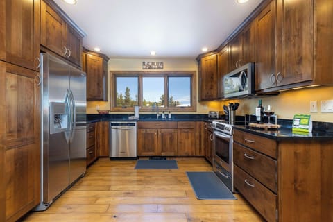 A fully stocked kitchen with ample counter space, and a new refrigerator. The windows offer stunning east-facing views of sunrises, Keystone Resort, and the iconic Grays & Torreys Peaks (14ers) on the Continental Divide.