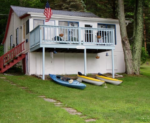 View of the cottage from the lake with kayaks.