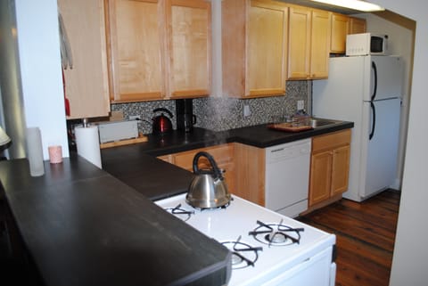 Slate counters and glass tiled kitchen backsplash