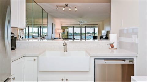 Farm style sink and quartz countertops with water views. 