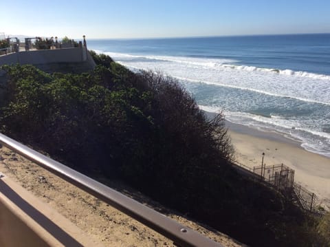 Staircase from pool area down to sandy beach