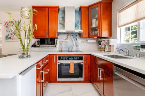 Kitchen: Marble-veined glass backsplash, smart appliances,& island for easy prep