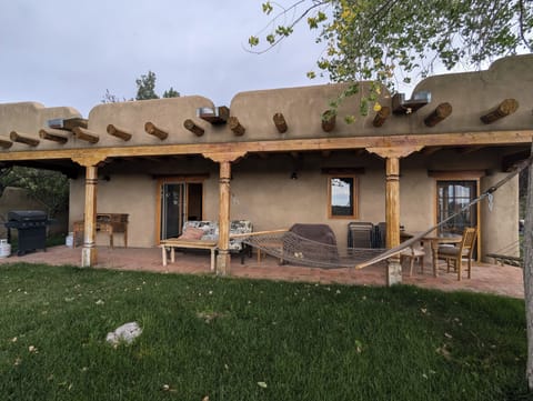 Back porch w. grill, dining table, hammocks and couch.