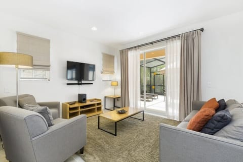 Spacious living room with plenty of natural light and a cozy seating area for relaxation.