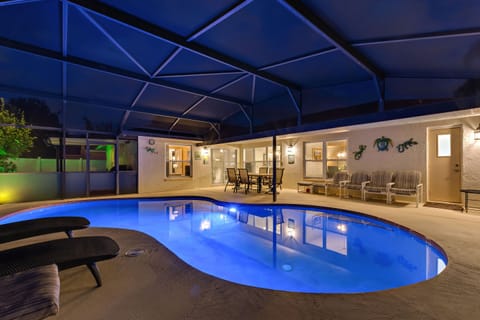 Relax by the illuminated pool under a screened lanai for ultimate privacy and comfort.