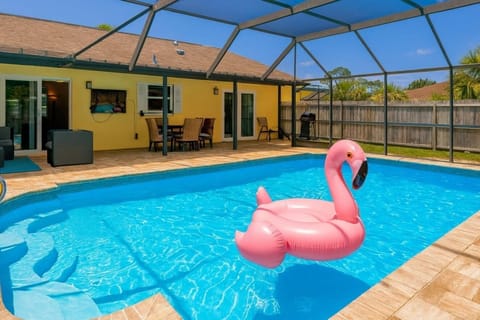 Sunlit pool patio with vibrant outdoor dining and lounge area