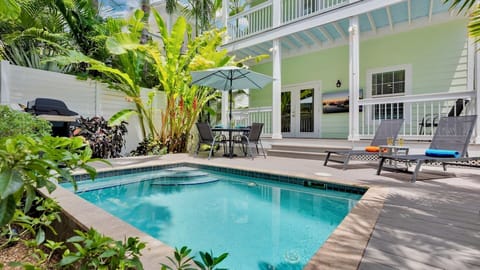 A pristine private pool awaits, framed by lush tropical plants and lounge chairs—your personal oasis under swaying palms. Perfect for sunny mornings or warm evenings beneath the stars.