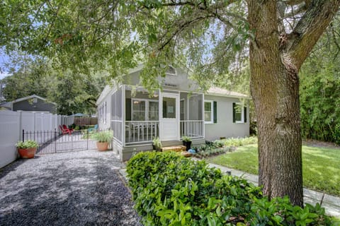 Normandy Cottage Front Exterior - Classic St. Simons cottage with screened porch, fenced yard, mature oaks, and parking beside the home.