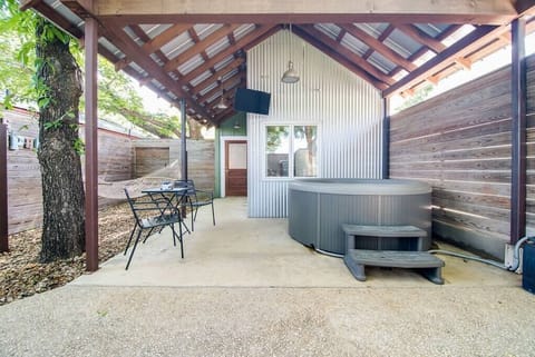 Private courtyard oasis – hot tub, hammock, outdoor shower, TV, and bistro seating.