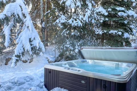 Unwind in the warmth of our hot tub, nestled among snow-covered trees.