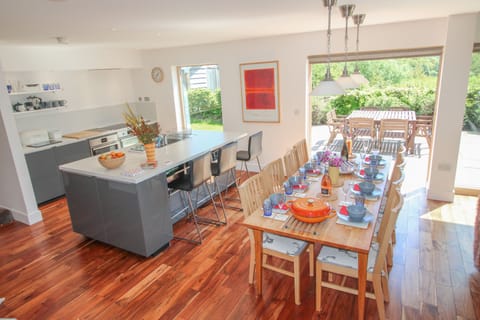 Fully equipped kitchen, breakfast bar and dining area with door out to patio
