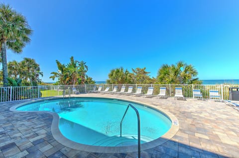 Sparkling pool area with tropical palms and ocean views, perfect for sunny Florida relaxation.