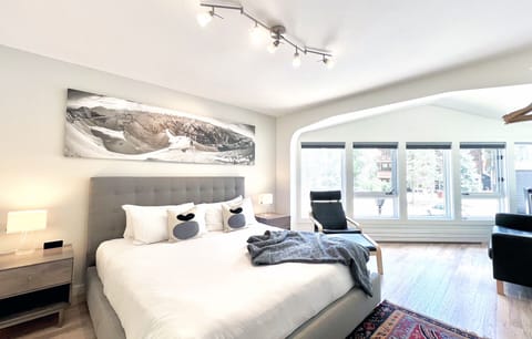 The spacious primary bedroom has a brand new king bed, large flat screen TV and a black leather sofa in the corner.