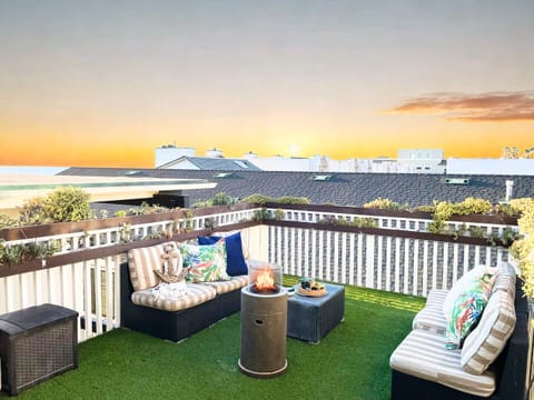 Unwind on your private terrace with cozy seating and stunning sunset views over the neighborhood rooftops.