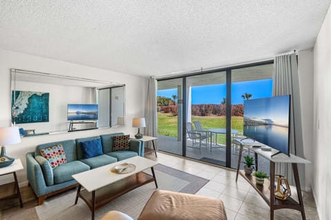 Relax in this cozy living room with 55" LCD TV and a stunning patio view of the ocean