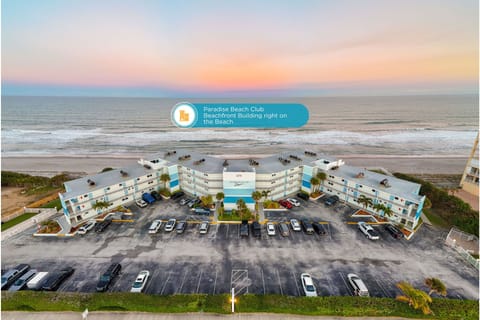 Elevated view of Paradise Beach Club, highlighting the beachfront building set directly along the shoreline with the ocean stretching behind it.