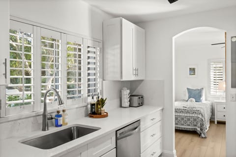 Sun-filled kitchen with plantation shutters and a clean coastal design.