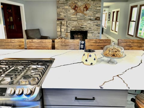 View from kitchen to sitting area. - Coffee maker, Dishes & utensils, Dishwasher, Microwave, Oven, Pantry items, Refrigerator, Stove, Toaster, Dining table, Kitchen island, Cookware, Spices.