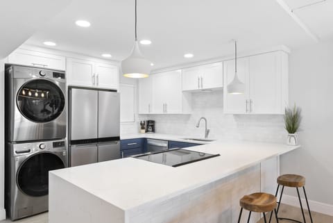 A sleek and contemporary kitchen featuring high-end appliances and laundry area.