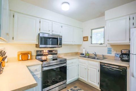 The kitchen contains a dishwasher, sink with garbage disposal, electric range, microwave and washer & dryer.