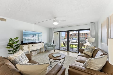 Kick back in this sun-filled living room with cozy seating, a smart TV, and sliding doors that open straight to your private balcony