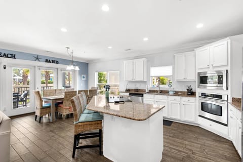 A large kitchen with granite countertops, and stainless steel appliances.