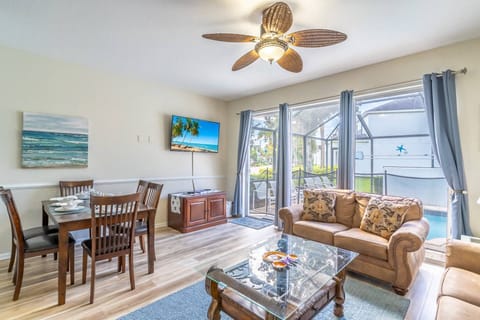 Living Area Features Easy Access To The Pool Area, A Large Wall Mounted Flat Screen TV