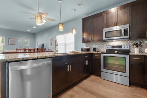 The kitchen is equipped with stainless steel appliances and granite countertops and is open to the entire family area
