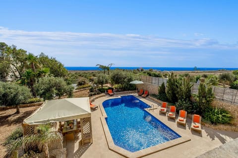 Large pool, garden area, and beautiful view at The Almonds Holiday Home in Gozo