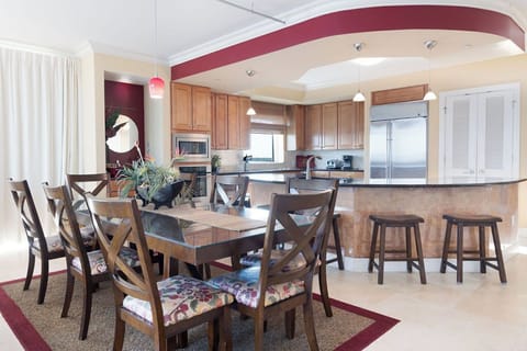 Dining Area - The open dining area features a table with seating for 8 with additional seats offered at the adjacent bar.