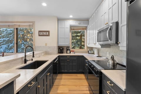 Full kitchen featuring stainless steel appliances, and breakfast bar seating 4.