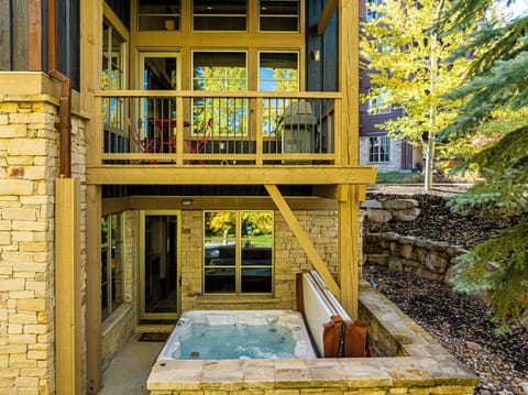 Beautiful exterior entry surrounded by stone and greenery
