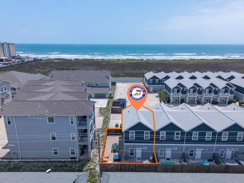 Aerial view shows beachfront vacation rentals near the ocean with natural dunes and coastal vegetation creating a peaceful seaside setting.