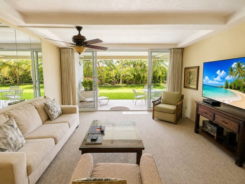 Unwind in your sunlit living space where floor-to-ceiling glass doors open to lush tropical gardens and your own private patio—perfect for morning coffee or sunset relaxation.