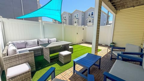 Your private outdoor oasis features comfortable wicker seating, artificial turf, and a turquoise shade sail for perfect relaxation under the sun.