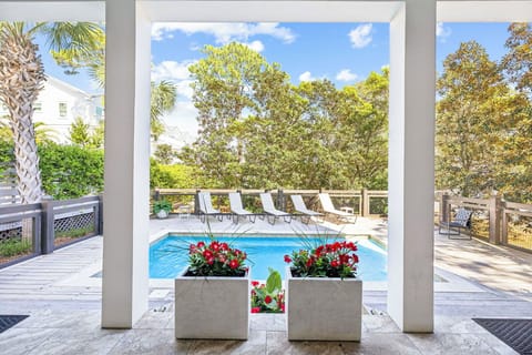 Your private pool awaits, framed by lush trees and sun loungers, where mornings feel serene and afternoons invite refreshing dips under bright blue skies.