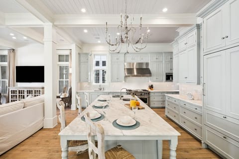 Gather around this elegant marble island where your mornings begin with coffee and conversation in this chef's dream kitchen.