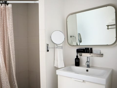 Bathroom with toilet, shower, and sink.