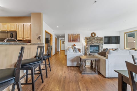Relax in your spacious open-concept retreat, where cozy seating surrounds a stone fireplace and the kitchen invites culinary adventures.