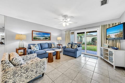 Stretch Out and Unwind in This Comfy Living Room with Doors Opening to The Patio