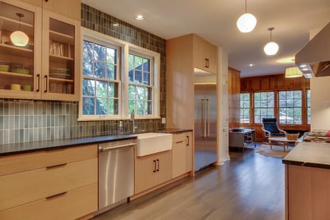 The modern kitchen is complete with a 6 burner Thermador range, farmhouse sink and soapstone counter tops.