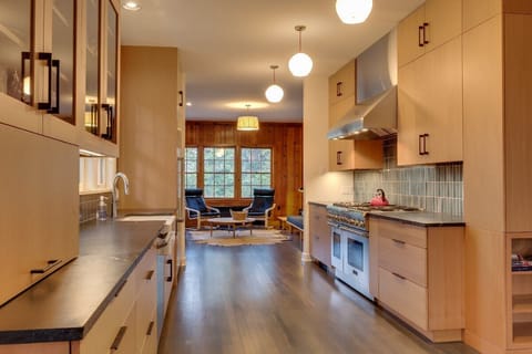 The modern kitchen is complete with a 6 burner Thermador range, farmhouse sink and soapstone counter tops.