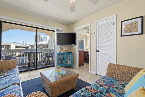 Living Area - The spacious living area features plenty of seating, a mounted television, and sliding door to the balcony.