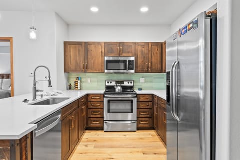 Full kitchen featuring stainless steel appliances and breakfast bar seating.