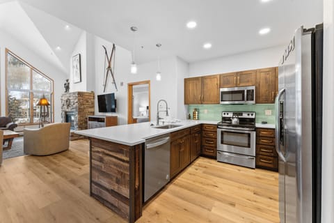 Full kitchen featuring stainless steel appliances and breakfast bar seating.