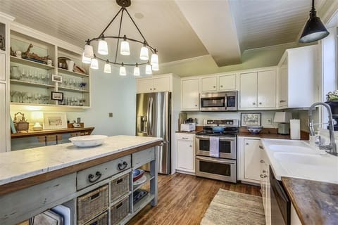 Main level kitchen - The main-level kitchen is fully equipped and features stainless-steel appliances, providing an ideal space for preparing meals for your entire group.