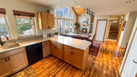 Open kitchen with polished countertops and a direct line of sight to the stunning vaulted living space.