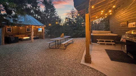 Step into a private backyard with hot tub, fire-lit pavilion, and picnic dining